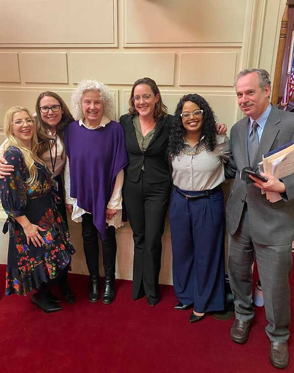 Tricia Newalu and Becca clearly pose with RI House Representatives following the House Judiciary Committee Hearing.